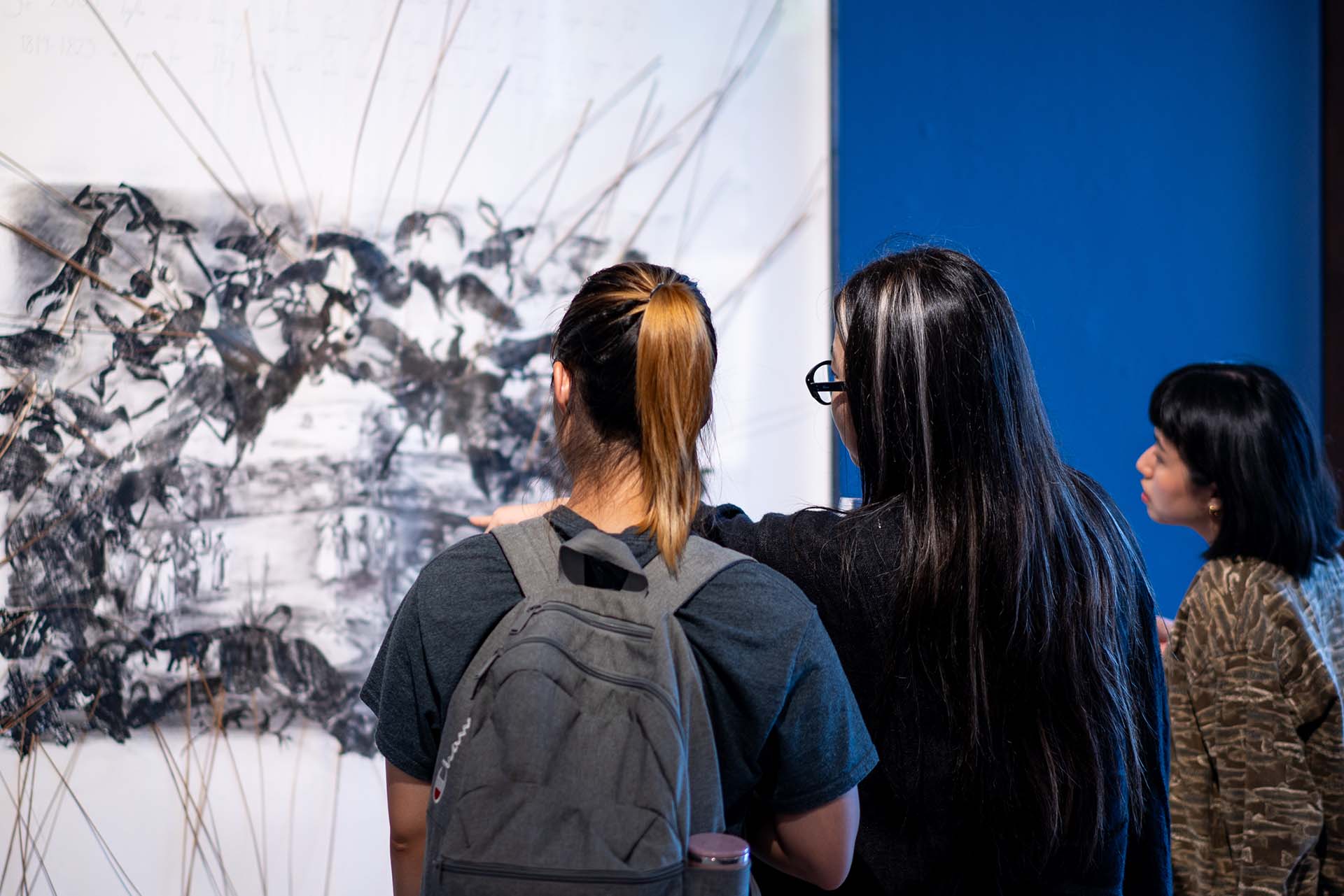 Backviewof3womenlookingatanartwork